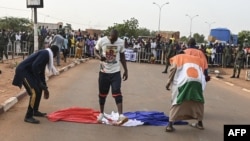 FILE - Protesters defile a French national flag during a rally in Niamey, Niger, Sept. 1, 2023, demanding the departure of French troops from Niger.