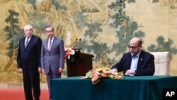 Mussa Abu Marzuk, a senior member of Hamas, right, signs a document as China's Foreign Minister Wang Yi, second left, and Mahmoud al-Aloul, vice chairman of Fatah, look on at the Diaoyutai State Guesthouse in Beijing, July 23, 2024. 
