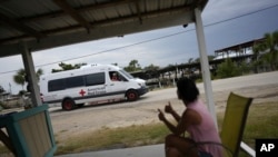 Renee Futch gives thumbs-up to a passing American Red Cross team, as she sits outside her storm-damaged live bait business in Horseshoe Beach, Fla., Sept. 1, 2023, two days after the passage of Hurricane Idalia.
