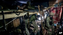 Ukrainian paratroopers of 80 Air Assault brigade rest inside a dugout at the front line near Bakhmut, Ukraine, March 10, 2023.