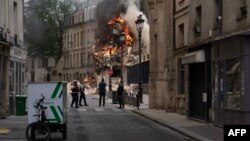 Smoke billows from the rubble of a building at Place Alphonse-Laveran in the 5th arrondissement of Paris, June 21, 2023. Witnesses told BFM TV there had been a strong smell of gas moments before the blast.