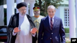 FILE - Iranian President Ebrahim Raisi, left, walks with Pakistan's Prime Minister Shehbaz Sharif during a welcome ceremony in Islamabad, Pakistan, April 22, 2024. (Prime Minister Office via AP)
