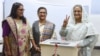 FILE - Bangladeshi Prime Minister Sheikh Hasina flashes the victory symbol after casting her vote, as her daughter Saima Wazed and her sister Sheikh Rehana look on in Dhaka, Dec. 30, 2018. Wazed's nomination for a senior regional WHO position has triggered controversy.
