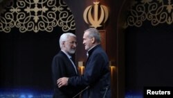 Kandidat presiden Iran Masoud Pezeshkian dan Saeed Jalili berpartisipasi dalam sesi debat di sebuah studio televisi di teheran, Iran, pada 1 Juli 2024. (Foto: Morteza Fakhri Nezhad/IRIB/WANA (West Asia News Agency)/Handout via Reuters)