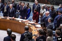 After Ukraine Foreign Minister Dmytro Kuleba led a moment of silence for victims of war in his country, the U.N. Security Council stands for a second tribute at the insistence of Russian envoy Vassily Nebenzia, Feb. 24, 2023, at U.N. headquarters.