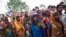 FILE - Onlookers stand at the site where two teenage girls, who were raped, were hanged from a tree at Budaun district in the northern Indian state of Uttar Pradesh, May 31, 2014. 