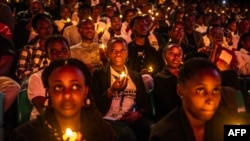 Young Rwandans hold flameless candles while taking part on a vigil during the commemorations of the 30th Anniversary of the 1994 Rwandan genocide at the BK Arena in Kigali, April 7, 2024. 