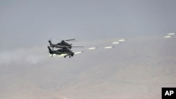 FILE - In this handout photo released by Russian Defense Ministry Press Service, Chinese military helicopter gunships fire rockets during joint war games held by Russia and China in northwestern China, Aug. 13, 2021. 