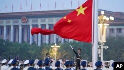 FILE - A Chinese honor guard unfurls the Chinese national flag at ceremony marking the 73rd anniversary of the founding of the People's Republic of China, in Beijing, Oct. 1, 2022.