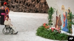 Pope Francis prays in front of a Nativity scene as he leaves the Paul VI hall at the end of his meeting with Vatican employees for the season greetings at the Vatican, Dec. 21, 2023.