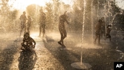In this file photo, children play with water at a fountain during a heat wave, at Stavros Niarchos foundation Cultural Center in Athens, July 21, 2023. (AP Photo/Petros Giannakouris, File)