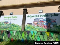 In the solar forest, the community can access energy to charge their devices in an area decorated by local artists. (Salome Ramirez/VOA)