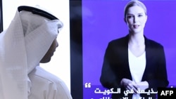 A journalist watches an introductory video by the 'artificial intelligence' anchor Fedha on the twitter account of Kuwait News service, in Kuwait City on April 9, 2023. 