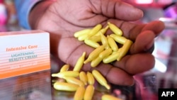 FILE - A beautician displays capsules and cream used for skin-lightening at a beauty shop, in Nairobi, Kenya, July 6, 2018.