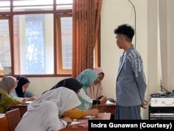 Indra mengajar di kelas dengan memakai baju berdesain unik, kadang dia membeli karya siswa untuk memacu kreativitas mereka. (Foto: Courtesy/Indra G)