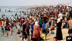 Familias palestinas desplazada por la guerra en curso con Israel buscan alivio del calor a lo largo del mar Mediterráneo en la playa de Khan Younis, Franja de Gaza, el 20 de mayo de 2024.
