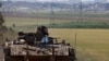 An Israeli soldier gestures, as he rides in an armored personnel carrier (APC), near the Israel-Gaza border, in Israel, March 10, 2024. 