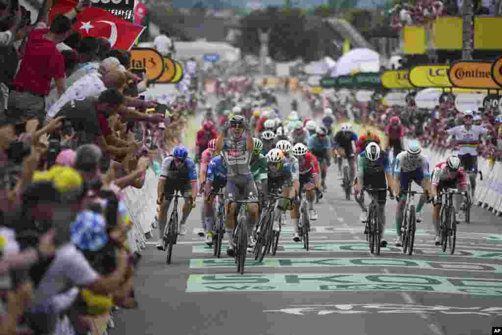 Belgium's Jasper Philipsen celebrates as he crosses the finish line to win the tenth stage of the Tour de France cycling race over 187.3 kilometers (116.4 miles) with start in Orleans and finish in Saint-Amand-Montrond, France.