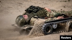 An ELECTROStretcher remote-controlled medical evacuation vehicle designed by Dmytro Mamonov carries a soldier during a presentation by various Ukrainian manufacturers at an undisclosed location outside Kyiv, Ukraine, May 28, 2024. (REUTERS/Thomas Peter)
