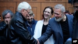 Nobel Peace Prize-winning journalist Dmitry Muratov, right, shakes hands with Oleg Orlov, co-chair of the Nobel Prize-winning Russian human rights organization Memorial after a court session in Moscow, Oct. 11, 2023.