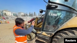 Akin Bozkurt operates a bulldozer at the site of collapsed buildings, taking part in the efforts to find bodies under rubble in the aftermath of the deadly earthquake in Kahramanmaras, Turkey, Feb. 18 2023. 