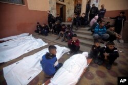 Palestinians mourn relatives killed in the Israeli bombardment of the Gaza Strip outside a morgue in Khan Younis on Dec. 15, 2023.