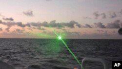 FILE - This photo provided by the Philippine Coast Guard shows a green military-grade laser light from a Chinese coast guard ship in the disputed South China Sea on Feb. 6, 2023. 