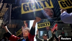 Anti-Trump protesters hold placards outside Trump Tower, in New York City, May 31, 2024.