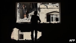 Palestinians inspect the damage around the Derby family house struck in Israeli bombardment of Rafah's Tal al-Sultan district in the southern Gaza Strip on May 7, 2024.