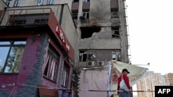 A resident walks past a partially destroyed residential building in Kyiv after a Russian drone strike, May 28, 2023. Russia attacked Kyiv with drones overnight Saturday-Sunday.