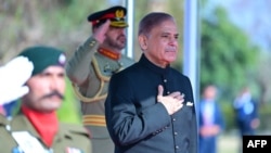 In this handout picture taken and released by Pakistan Prime Minister's Office on March 4, 2024, Pakistan's newly sworn-in Prime Minister Shehbaz Sharif, right, inspects the guard of honor at the Prime Minister House in Islamabad. 