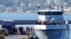 FILE - Migrants disembark from a Greek coast vessel after a rescue operation, at the port of Mytilene, on the northeastern Aegean Sea island of Lesbos, Greece, Aug. 28, 2023.