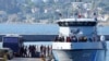 FILE - Migrants disembark from a Greek coast vessel after a rescue operation, at the port of Mytilene, on the northeastern Aegean Sea island of Lesbos, Greece, Aug. 28, 2023.