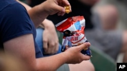 A spectator snacks at a baseball game in Baltimore, Maryland, April 26, 2023, in Baltimore.