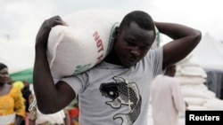 FILE - A man receives a bag of food from the government during the distribution of food in Abuja by the government to cushion the high cost of living, Sept. 20, 2022. Nigeria's annual inflation rose to a 28-year high of 33.95% in May.