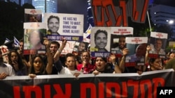 Relatives of Israeli hostages taken captive on October 7 by Palestinian militants in Gaza hold portraits of those taken during a demonstration in Tel Aviv, Israel, calling for their release, May 4, 2024.
