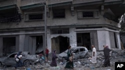 Palestinians walk amid the rubble following Israeli airstrikes that razed swaths of a neighborhood in Gaza City, Oct. 10, 2023.