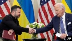 FILE - President Joe Biden shakes hands with Ukrainian President Volodymyr Zelenskyy in Paris, June 7, 2024.