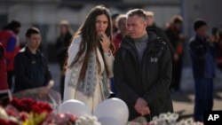 A couple stand at a makeshift memorial in front of the Crocus City Hall on the western outskirts of Moscow, March 27, 2024. The March 22 massacre at the venue was the deadliest extremist attack on Russian soil in nearly two decades.