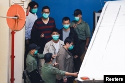 FILE - Pro-democracy activists Sam Cheung, Lam Cheuk-ting, Raymond Chan Chi-chuen and Owen Chow walk to a prison van to head to court, over national security law charges, in Hong Kong, China March 2, 2021. (REUTERS/Tyrone Siu/File Photo)