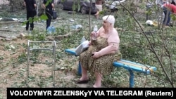 A resident sits near her residential building damaged by a Russian missile strike in Mykolaiv, Ukraine, July 19, 2024. Russian drones and missiles struck Ukraine overnight, killing two and hitting energy facilities and railway infrastructure across the country, said officials. 