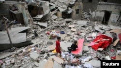 Palestinian children inspect the site of an Israeli strike on a house in Rafah in the southern Gaza Strip, April 27, 2024.