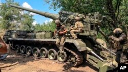 Russian soldiers operate 2S7M Malka self-propelled cannon in an undisclosed location, in this photo taken from video, July 23, 2024. (Russian Defense Ministry Press Service via AP)