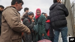 FILE - Syrians wait to cross into Syria near Antakya, Turkey, Feb. 21, 2023. Turkish President Recep Tayyip Erdogan accused opposition parties of stoking racism, July 1, 2024, a day after Syrian-owned shops were set afire in a central Turkey neighborhood.
