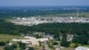 A school and neighborhoods sit near the Denka Performance Elastomer Plant, back, in Reserve, La., Sept. 23, 2022. The plant emits chloroprene, listed as a carcinogen in California and a likely one by the Environmental Protection Agency.