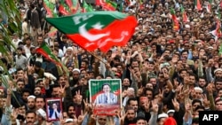 FILE - Pakistan Tehreek-e-Insaf (PTI) party supporters hold portraits of former prime minister Imran Khan as they protest against the alleged skewing in country's national election, in Peshawar, March 10, 2024. 