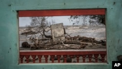 A window frames a portion of the shore littered with debris left from flooding driven by a Gulf of Mexico sea-level rise, in the coastal community of El Bosque, in the state of Tabasco, Mexico, Nov. 29, 2023.