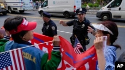 People gather outside Manhattan Criminal Court to watch former President Donald Trump's motorcade to pass after the guilty verdict announced against him, May 30, 2024, in New York.