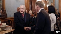 Mexican President Andres Manuel Lopez Obrador, left, arrives at the Palacio Nacional for a meeting with the U.S. delegation and members of his cabinet in Mexico City, Dec. 27, 2023. 