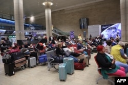 Passengers wait at Ben Gurion Airport near Tel Aviv, Israel, on Oct. 7, 2023, as flights are canceled because of the Hamas surprise attack.